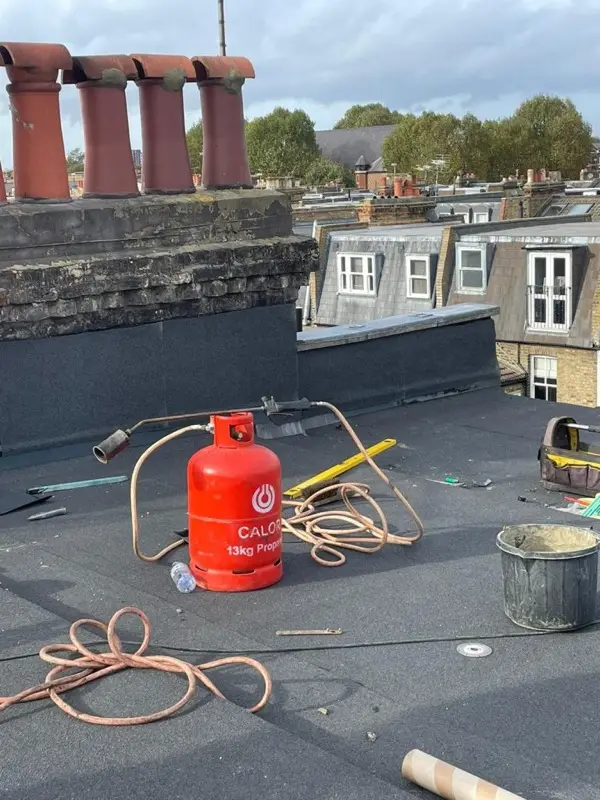 Flat roofing work in progress with torch-on felt being bonded to the deck